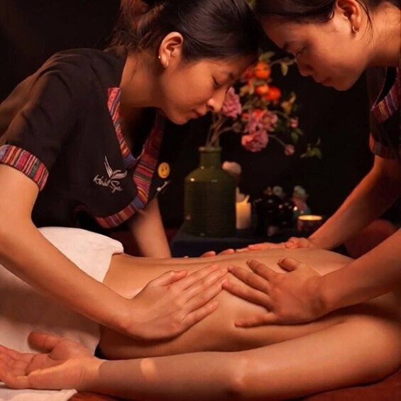 A massage session with a person lying face down, receiving hands-on therapy. 5