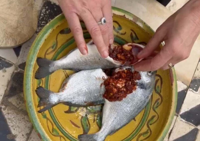 Two fish on a yellow plate with a red sauce. 3