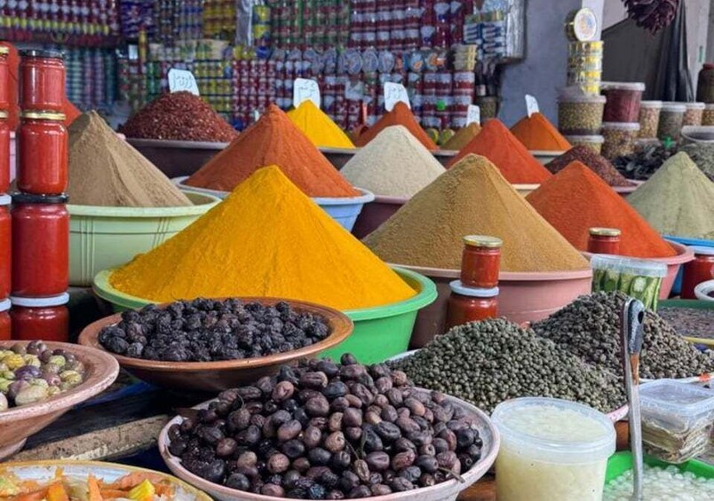 A variety of spices and dried goods displayed in containers at a market. 1