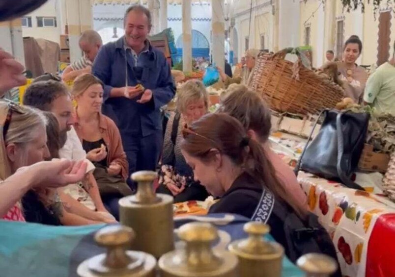 A group of people gathered around a table with various objects, possibly for a workshop or meeting. 2