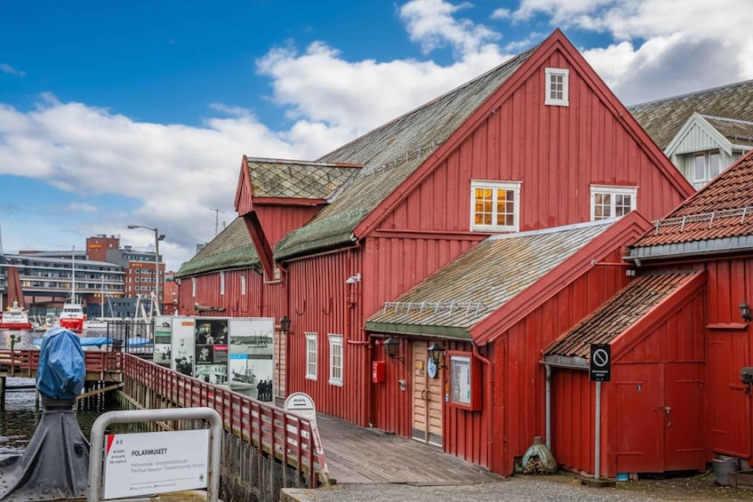 A red wooden building with a dock, a sign for POLARMUSEET, and a no-entry sign. 1