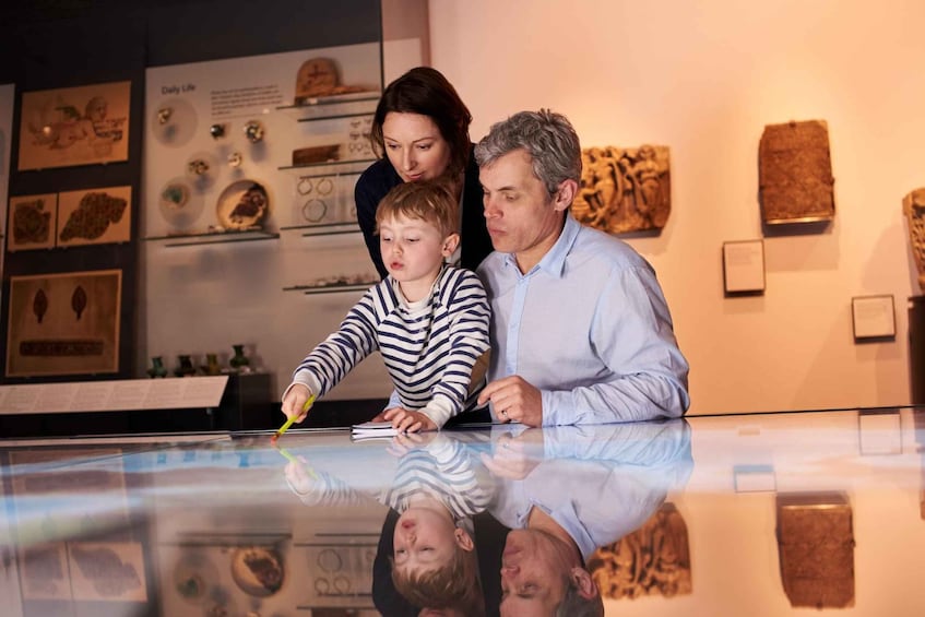 A family at an exhibit with a glass table reflecting their image. 5