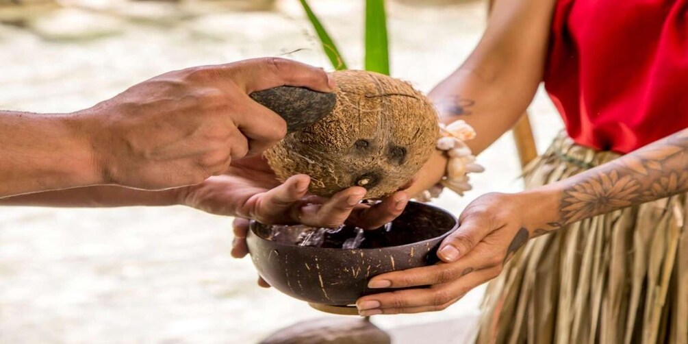 A person pouring coconut water from a coconut into a bowl. 5