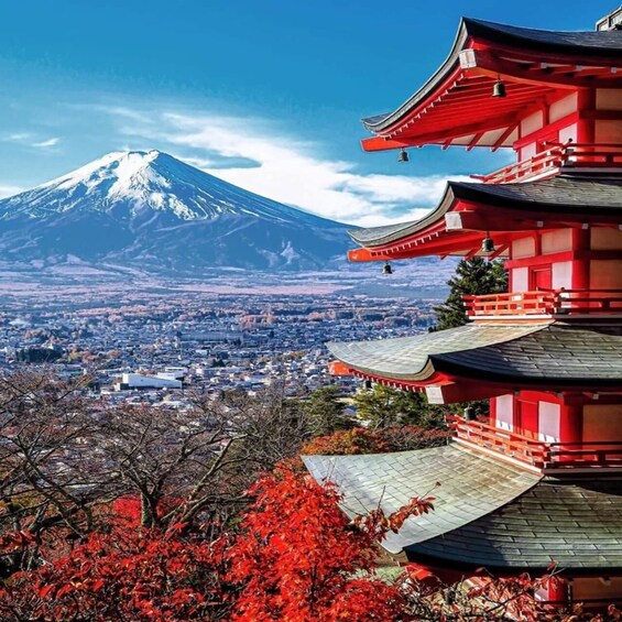 A traditional Japanese pagoda with red accents, a snow-capped mountain in the background, and autumn foliage. 1