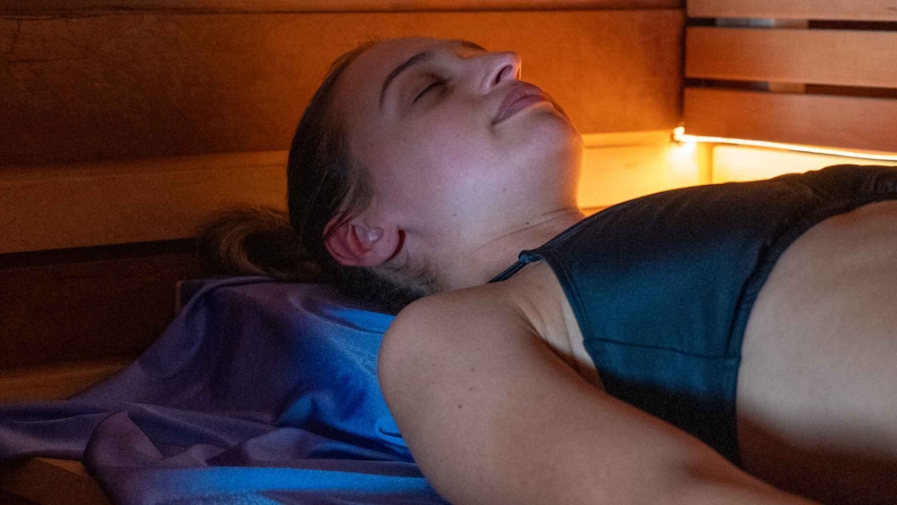A person lying on a bench in a dimly lit area. 1