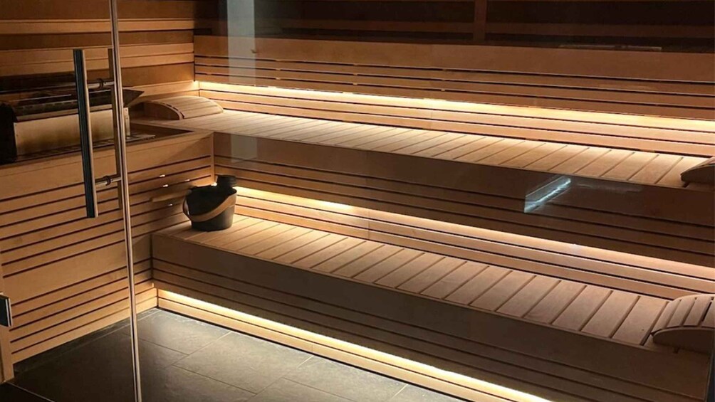 A modern sauna with wooden slats and a glass door. 3