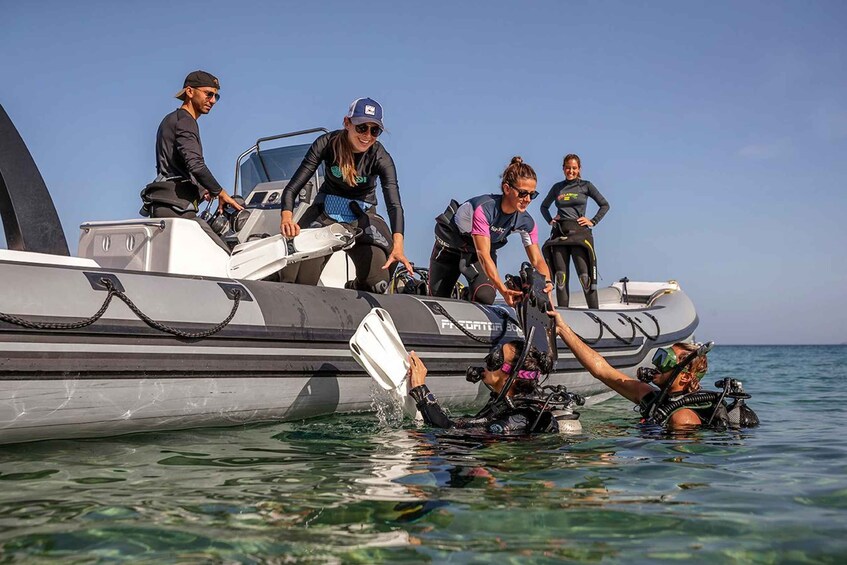 A group of people on a boat preparing scuba diving gear. 3