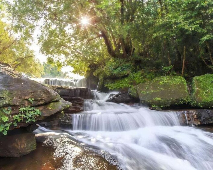 A waterfall cascading over rocks in a forested area. 4