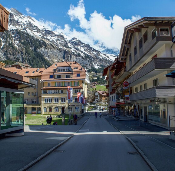 A mountain town street with buildings, flags, and a clear sky. 3
