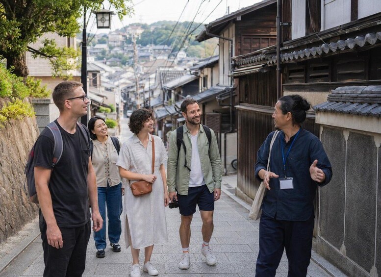 A group of people walking on a narrow street lined with traditional buildings. 5