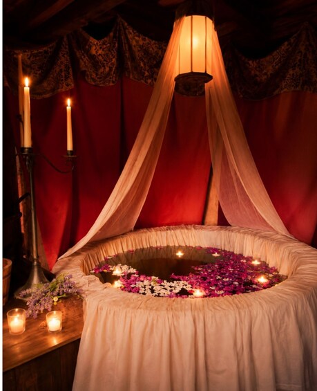 A romantic setting with a canopy, candles, and flowers. 1