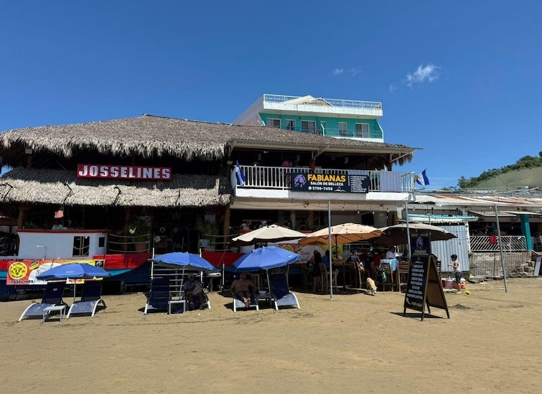 A beachside establishment with a thatched roof and outdoor seating. 2