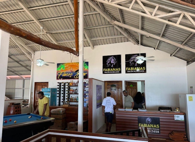A billiards room with a pool table, a bar area, and two 'Fabianas Salon de Belleza' signs. 5