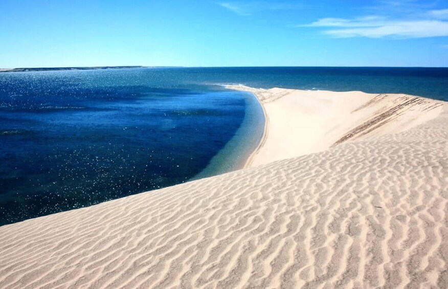 A sandy beach with a clear blue ocean. 4