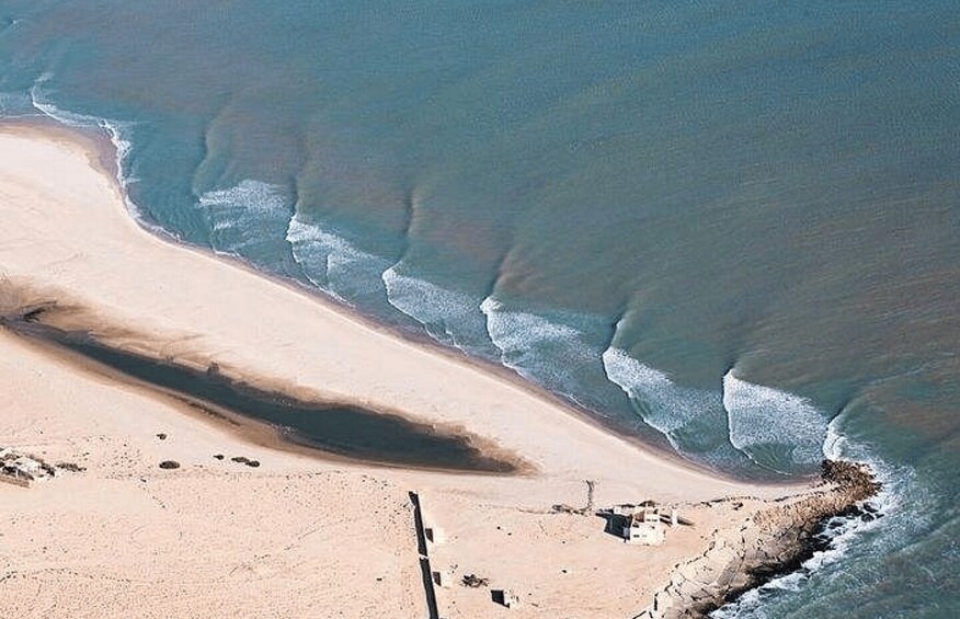 A sandy beach with waves approaching the shore. 5