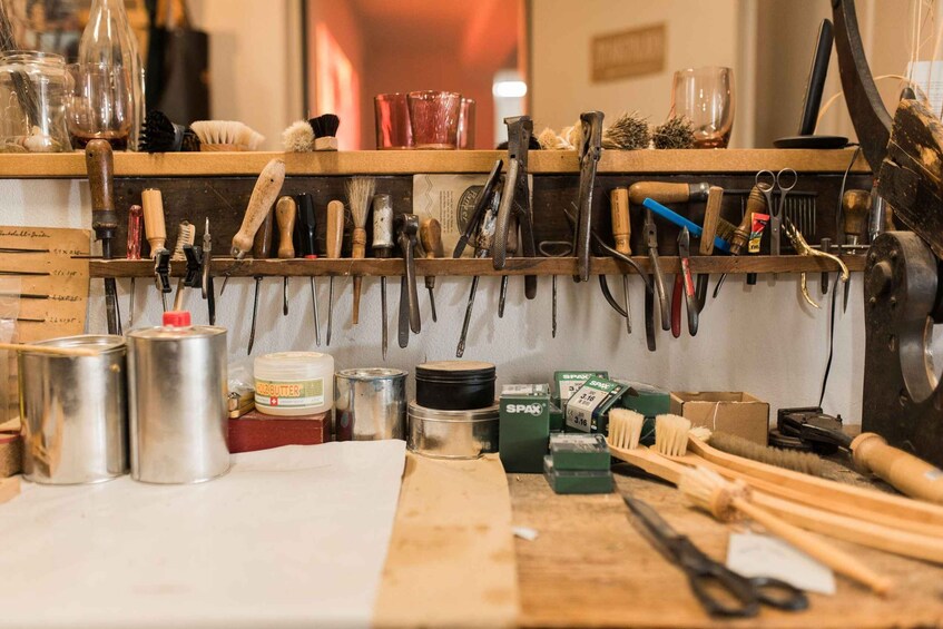 A cluttered workspace with tools, brushes, and containers. 3