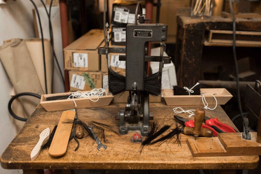 A woodworking bench with a sewing machine, tools, and materials. 4