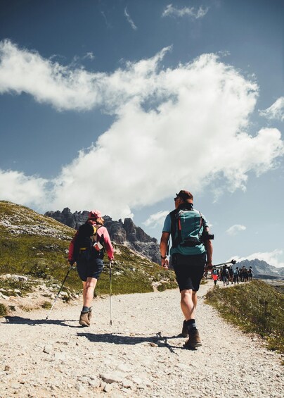 Hikers on a rocky trail with mountains in the background. 3