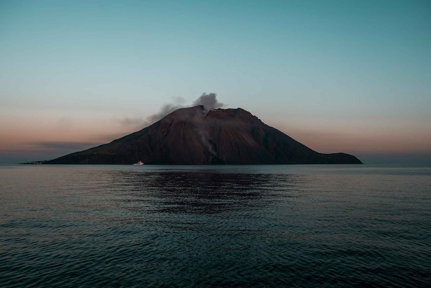 A mountain with a boat in the foreground. 1