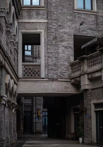 A multi-story building with a brick facade, large windows, and a covered entrance. 5