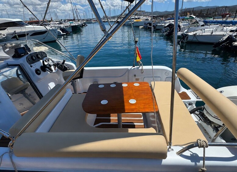 A boat's interior with a wooden deck, control panel, and a flag. 4
