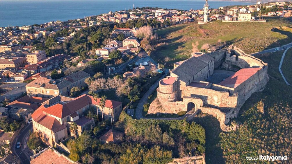 A coastal town with a prominent fortress, dense residential area, and a lighthouse. 3