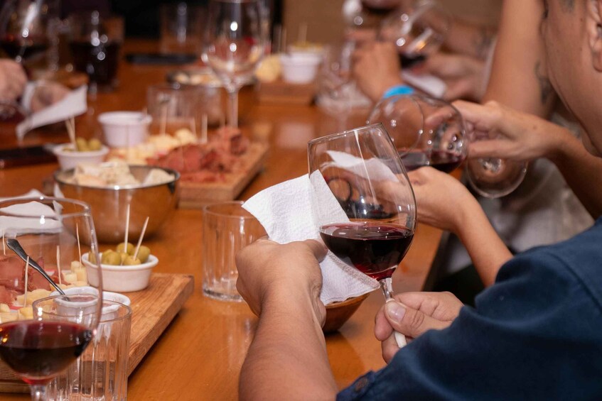 People sitting at a table with wine glasses and food. 3