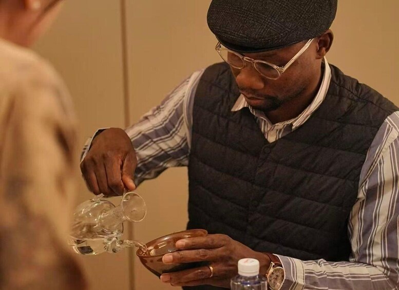 A person pouring liquid from a jug into a bowl. 2