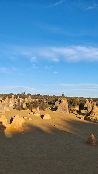 A desert landscape with prominent rock formations and sparse vegetation under a clear blue sky. 5