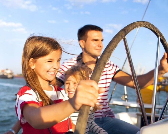 A family on a sailboat with a clear sky and calm sea. 5