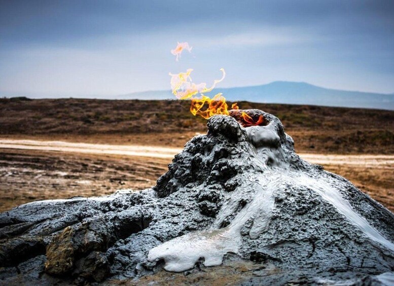 A volcanic eruption with lava flowing down a rocky terrain. 1