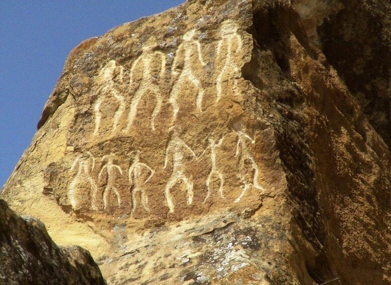 A rock with ancient carvings of human figures. 4