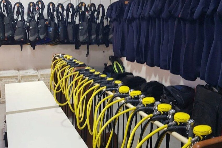 A row of yellow and black cables connected to yellow caps, with a white table and a black bag in the foreground. 3