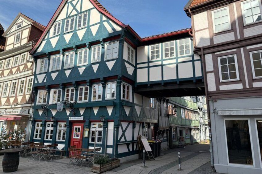 A traditional half-timbered building with a red door and white windows, surrounded by other historic buildings. 5