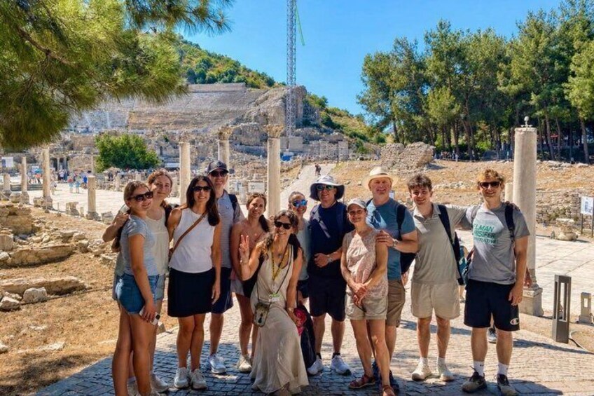 A group of people at an archaeological site with ancient ruins and columns in the background. 5