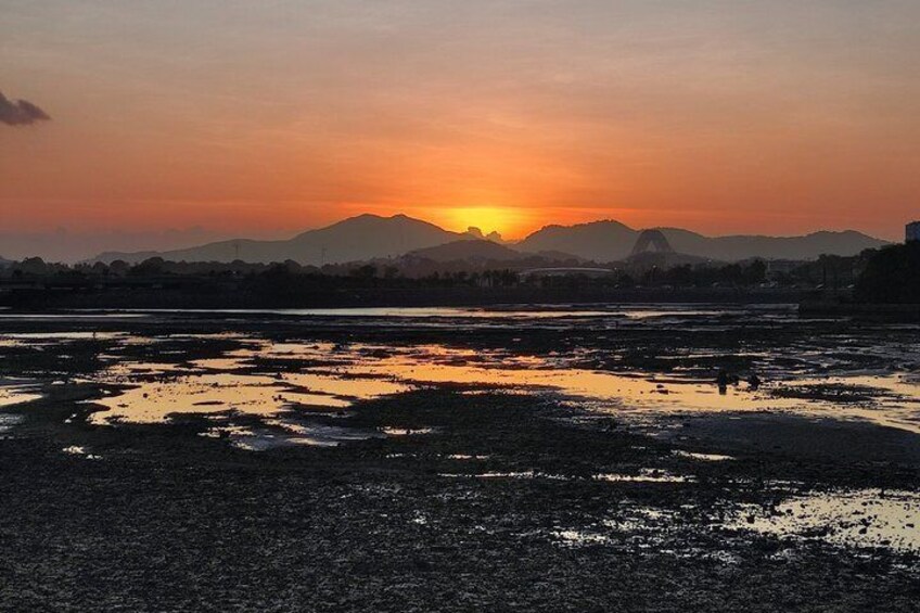 A sunset over a flooded landscape with mountains in the background. 2