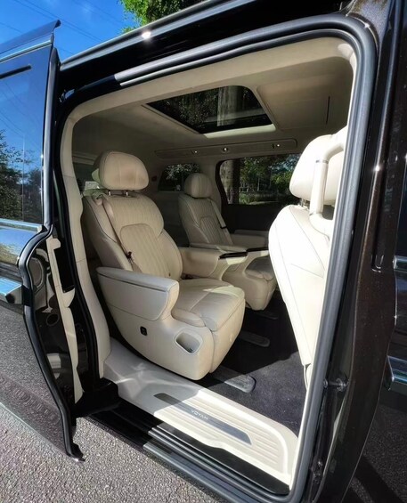 A vehicle interior with beige leather seats and a sunroof. 2