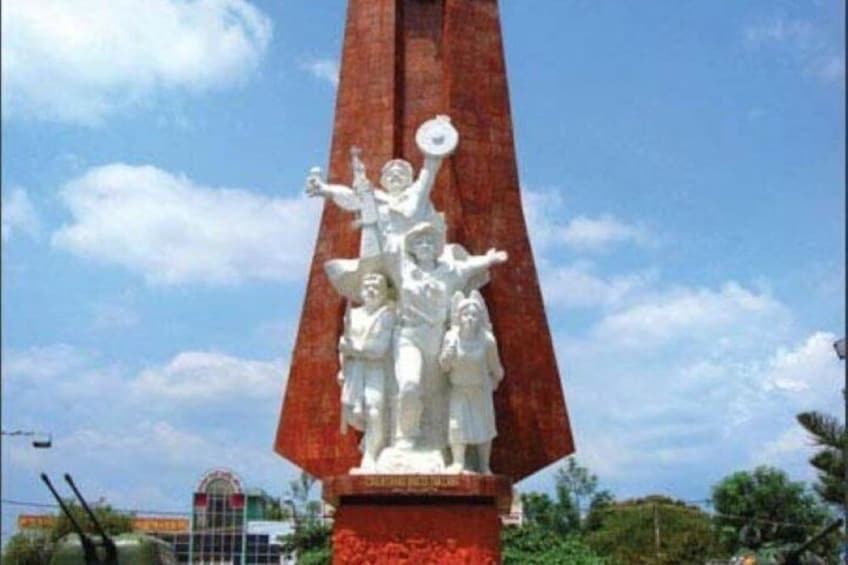 A tall red monument with a white statue of a figure holding a globe. 5