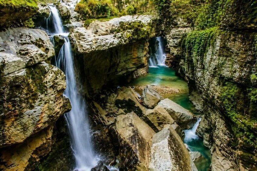 A waterfall cascading over rocks in a natural setting. 4