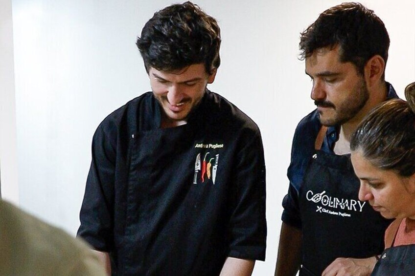 Three people in a room, one wearing a black shirt with a logo and another in a black shirt with 'COUNCIL' on it. 1