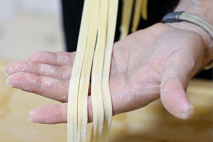 A hand holding uncooked pasta. 4