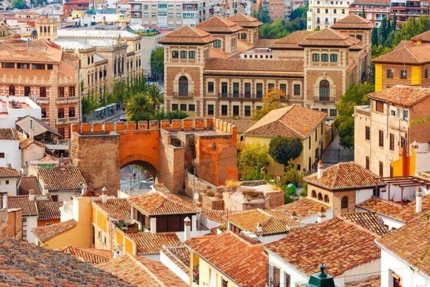 A historic cityscape with a prominent arch bridge, terracotta-roofed buildings, and a dense urban layout. 4
