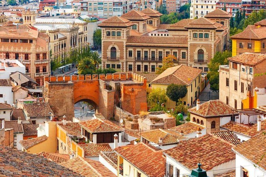A historic cityscape with a prominent arch bridge, terracotta-roofed buildings, and a mix of architectural styles. 4