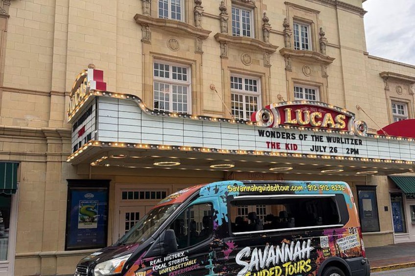 A theater with a marquee reading 'Lucas Wonders of the Wurlitzer The Kid' and a bus with 'Savannah Super Tours' branding. 4