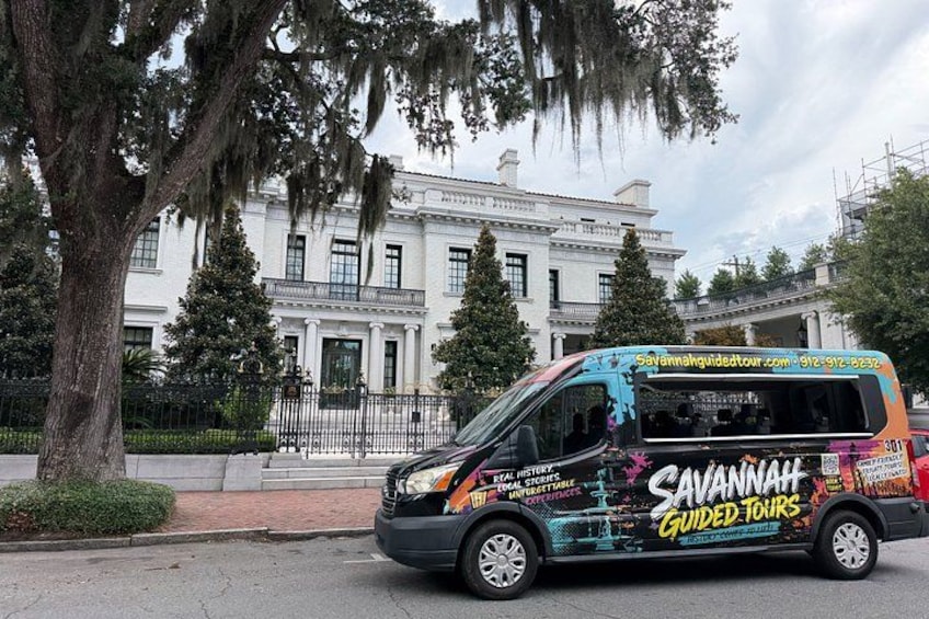 A tour bus parked in front of a historic building. 5