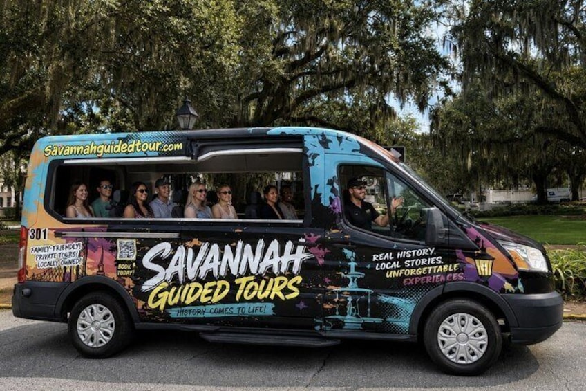 A tour bus with 'Savannah Guided Tours' branding and a website address. 1