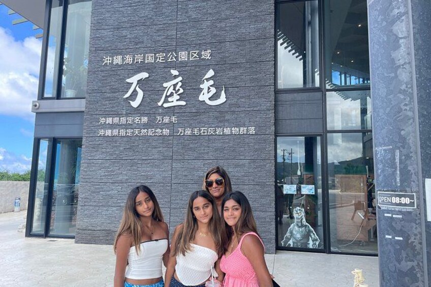 A building with large signage in a foreign language, a glass entrance, and a statue inside. 5