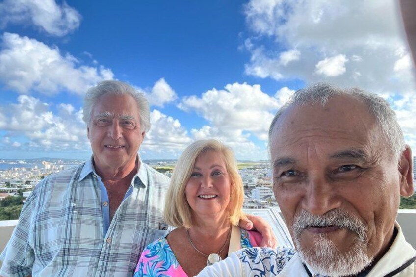 Three people on a rooftop with a cityscape in the background. 5