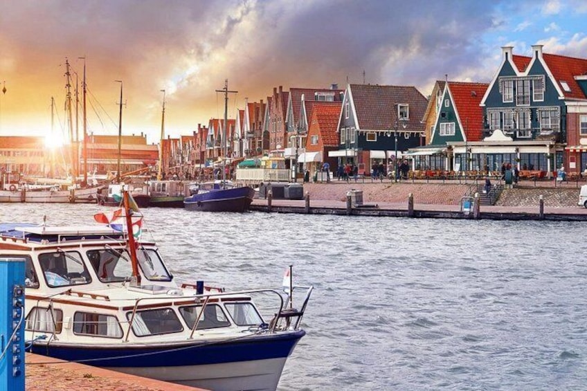 A harbor with boats, waterfront buildings, and a sunset. 2