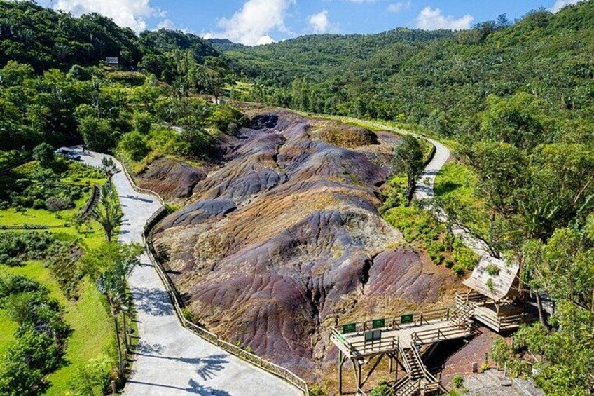 A winding road through a mountainous landscape with rocky terrain and greenery. 5